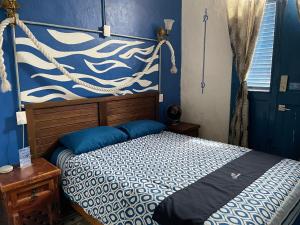 韦拉克鲁斯Chuchumbé Hotel & Hostal的一间卧室配有一张蓝色墙壁的床