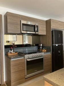 墨西哥城Yellow & Blue Apartment HP - Sur的厨房配有不锈钢炉灶和微波炉