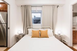 蒙特利尔Alywin Apartments in Hochelaga的卧室配有白色的床和窗户。