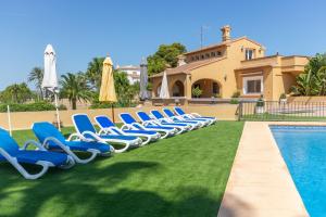 特乌拉达Villa Benimarco - Costa CarpeDiem的游泳池旁的一排蓝色躺椅
