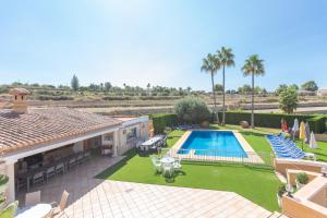 特乌拉达Villa Benimarco - Costa CarpeDiem的一座带游泳池和带椅子的庭院的房子