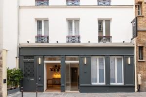 巴黎HOTEL AU COEUR DES ARTS ET METIERS的白色建筑的外墙,有黑色的入口