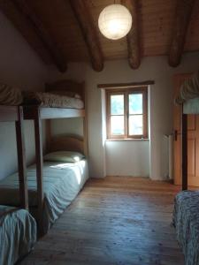 加尔尼亚诺Ca' del Rì的一间卧室设有两张双层床和一扇窗户。