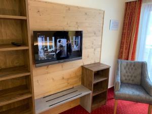 斯拉德明达斯普拉茨尔酒店的一间带电视和椅子的客厅