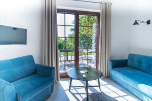 卡齐米日-多尔尼Kameralny domek Kazimierzówka的客厅配有2张蓝色的沙发和1张桌子