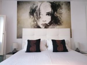 科斯蒂内什蒂Alexandra House的卧室配有白色床,上面有绘画作品
