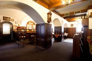 洪波莱茨乌伊希霍酒店的墙上有桌子和时钟的房间