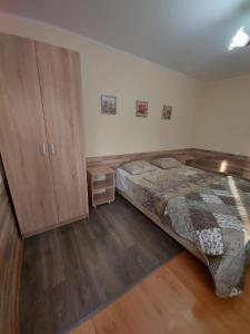 拉扎列夫斯科耶Svetlana的一间卧室配有一张床和一个木制橱柜