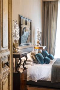 佛罗伦萨波迪赛丽酒店的一间卧室配有一张带蓝色枕头和镜子的床