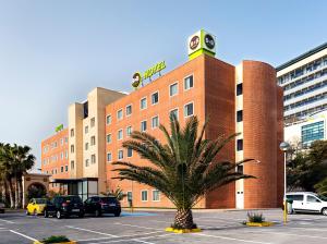 阿利坎特B&B HOTEL Alicante的停车场内棕榈树的建筑