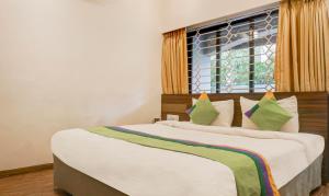 罗纳瓦拉Treebo Trend Five Elements Lonavala的一间卧室设有两张床和窗户。