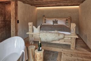 巴赫Lass Zeit am Lech的一间卧室配有一张床和一瓶葡萄酒