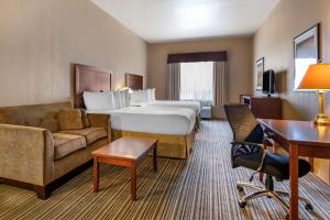 雷姆贝Quality Inn & Suites的酒店客房配有一张床、一张沙发和一张书桌。