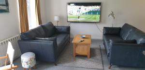 康内尔One The Cairns的客厅配有两张沙发和一台电视机