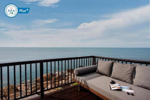 拉迈Silavadee Pool Spa Resort - SHA Extra Plus的俯瞰大海的阳台的沙发