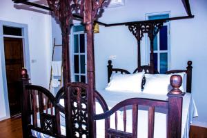 南威Nungwi Roses的一间卧室配有一张带白色床单的四柱床