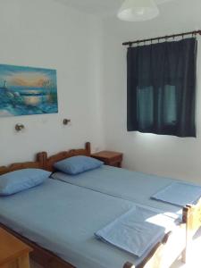 雷夫科斯卡尔帕索Nikos Taverna and Apartments的卧室设有两张单人床和窗户。