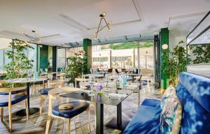 直布罗陀The Eliott Hotel的餐厅设有桌椅和窗户。