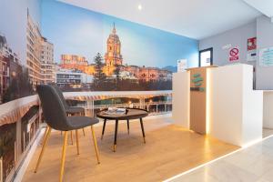 马拉加Málaga Rivas 34 Suites Homes的美景客房内的桌椅