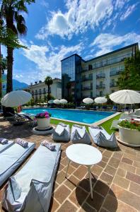加尔达湖滨拉佩而拉酒店的一座带桌椅的游泳池以及一座建筑