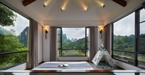 阳朔阳朔水岸花园江景酒店的客房设有大窗户和一张带帐篷的床。