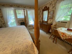 滨湖尼亚加拉Bernard Gray Hall Bed and Breakfast的卧室配有床、桌子和窗户。