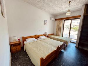 阿彻奇洛斯阿芙罗狄蒂膳食公寓的一间卧室设有两张床和窗户。