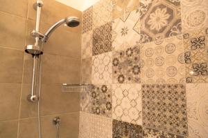 比谢列Domina Living Apartments - Presepe的浴室的墙壁上设有瓷砖,浴室内则设有淋浴。