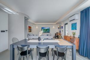 米欧纳VILLA ELEMENTA - A peaceful retreat的用餐室以及带蓝色桌椅的起居室。