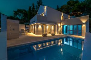 米欧纳VILLA ELEMENTA - A peaceful retreat的一座晚上设有游泳池的房子