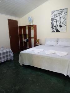 伊比科阿拉Pousada Raposa的一间卧室配有一张带白色床单的大床