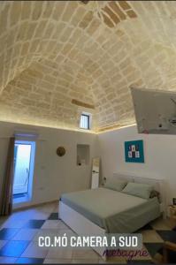 梅萨涅Co Mó - Camera a Sud - Affittacamere的一间卧室设有一张床和石质天花板