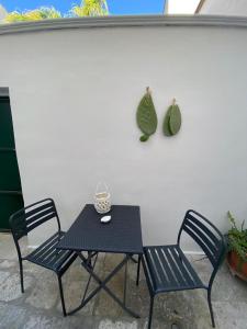 梅萨涅Co Mó - Camera a Sud - Affittacamere的一张桌子和两把椅子,坐在白色的墙壁旁