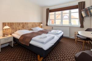 斯卡恩佛尔登斯酒店的一间卧室配有一张床、一张书桌和一个窗户。