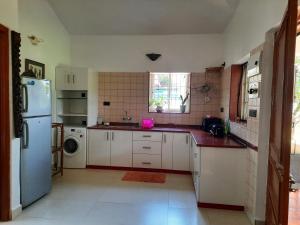 卡乌罗西姆Tobias Villas的厨房配有白色橱柜和白色冰箱。