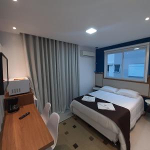 弗洛里亚诺波利斯Residencial Praia Mar的酒店客房配有一张床铺、一张桌子和一张书桌。