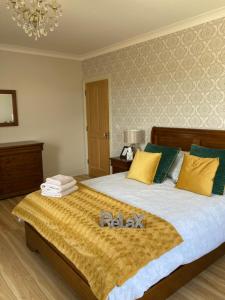 贝尔马利特Broadhaven Bay View Private House的一间卧室配有一张大床,提供黄色和绿色的枕头