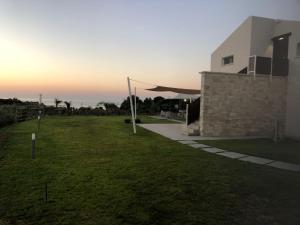 斯克佩罗Appartamenti in Villa Nature con vista mare e monti的一座草地庭院,毗邻一座享有日落美景的建筑