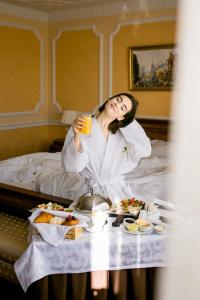 圣彼得堡艾米瑞达格兰德酒店的坐在床上的女人,带上一盘食物