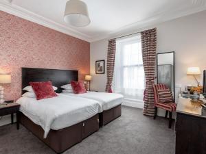 比加Kirkstyle Hotel的一间卧室配有一张带红色枕头的大床
