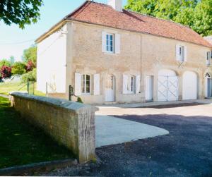 DamblainvilleChâteau du Mesnil Soleil , gites et chambres d'hôtes的一座古老的砖房,前面有石墙