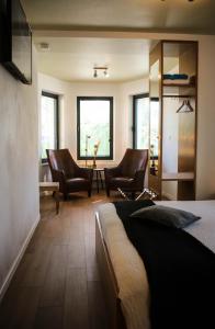 Erpe-Mere卡佩霍夫酒店的一间卧室配有两把椅子和一张位于房间的床