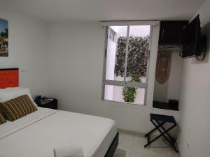 巴耶杜帕尔Escala Hotel的白色的卧室设有床和窗户