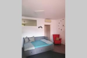 索马坎帕尼亚La Casetta, appartamento nel verde a Sommacampagna的一间卧室配有一张床和一张红色椅子