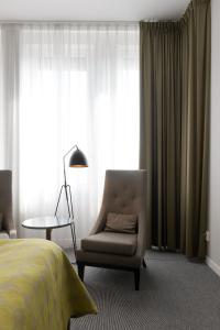 隆德隆德伊德恩精英酒店的一间卧室配有一张床、一把椅子和一盏灯