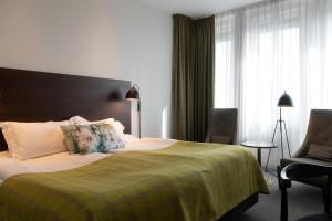 隆德隆德伊德恩精英酒店的配有一张床和一把椅子的酒店客房