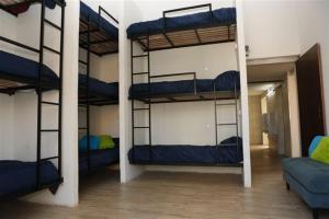 罗萨里奥Real Ros Hostel的带三张双层床和一张沙发的房间