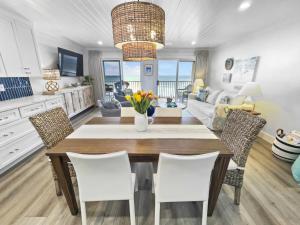 圣罗莎海滩Endless Waves -208 ES Condo的厨房以及带桌椅的起居室。