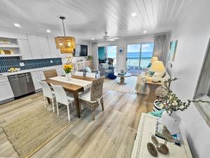 圣罗莎海滩Endless Waves -208 ES Condo的厨房以及带桌椅的起居室。