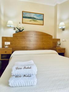 波多诺伏Hostal Casa Isabel的酒店客房,配有带毛巾的床
